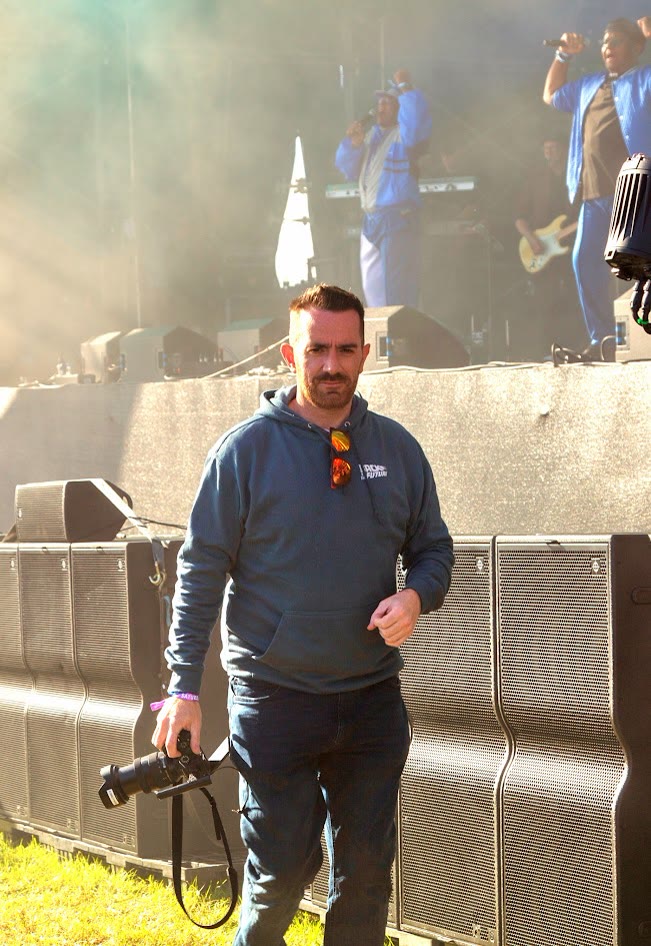 Chris Woollam, founder of Stern Digital, camera in hand at a festival main stage
